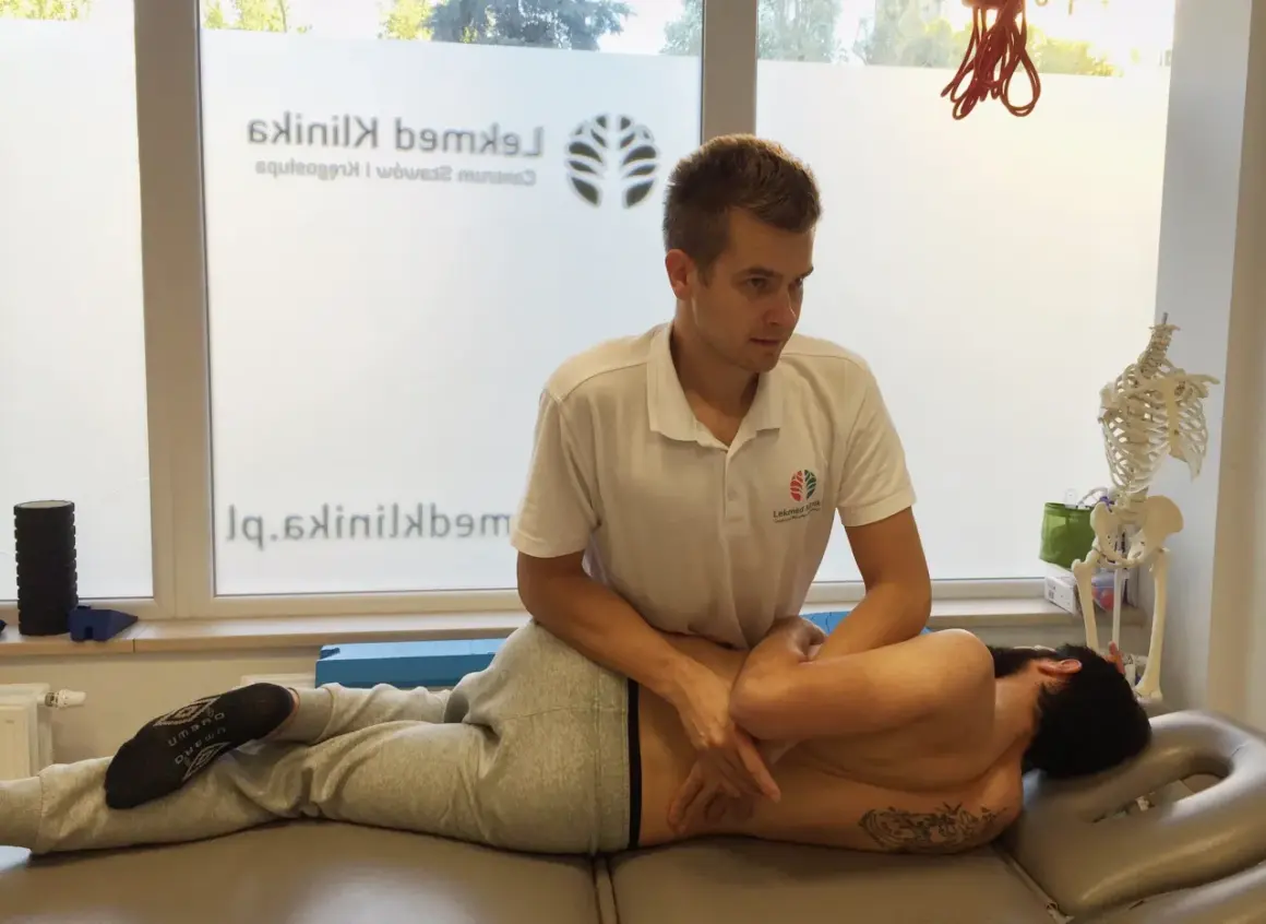 Fizjoterapeuta wykonuje masaż pleców, pomagając pacjentowi poczuć ulgę i dowiedzieć się, jak strzelić plecami.