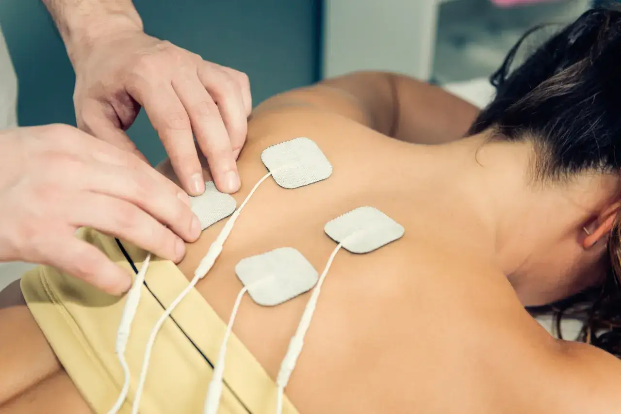 Fizjoterapeuta nakłada elektrody TENS na pacjenta